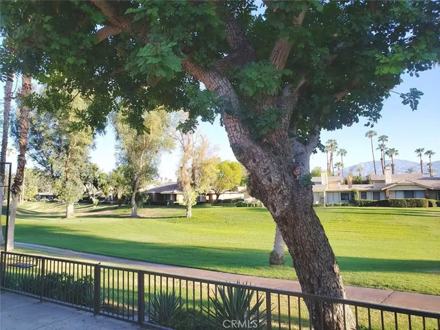 a view of a patio with couches table and chairs and potted plants