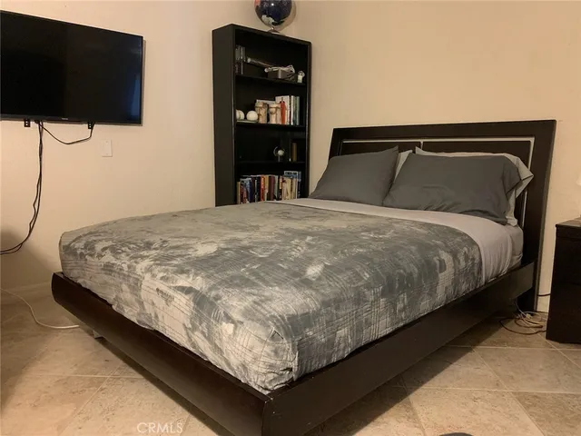 a bedroom with a bed and a window with balcony view