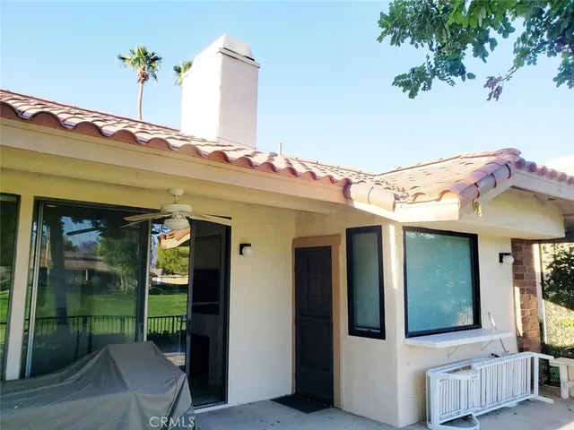 a view of a patio with couches table and chairs and potted plants