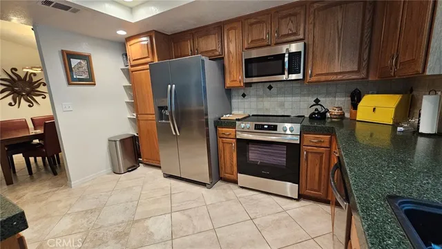 a kitchen with stainless steel appliances granite countertop a refrigerator and a sink