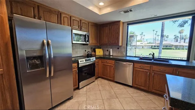a kitchen with stainless steel appliances granite countertop a refrigerator and a sink
