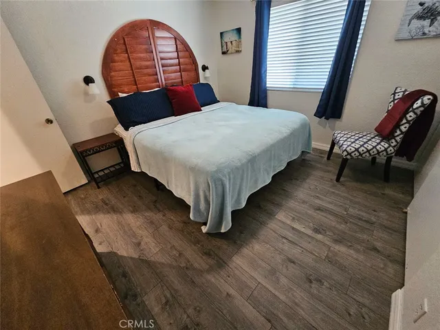 a bedroom with a bed a dresser and chair