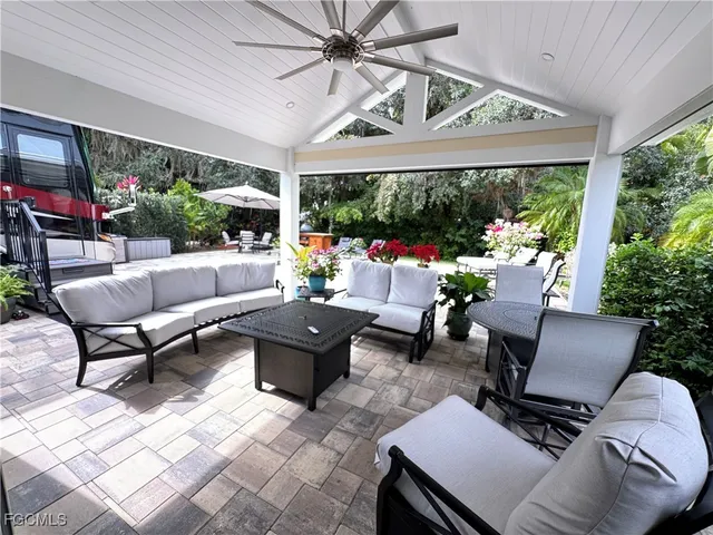a living room with patio furniture and a potted plant