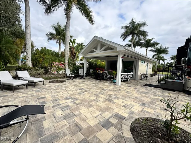 a view of a patio with table and chairs potted plants and a large tree