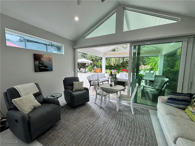 a living room with patio furniture and a potted plant