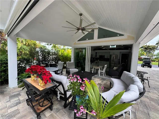 a living room with patio furniture and a potted plants