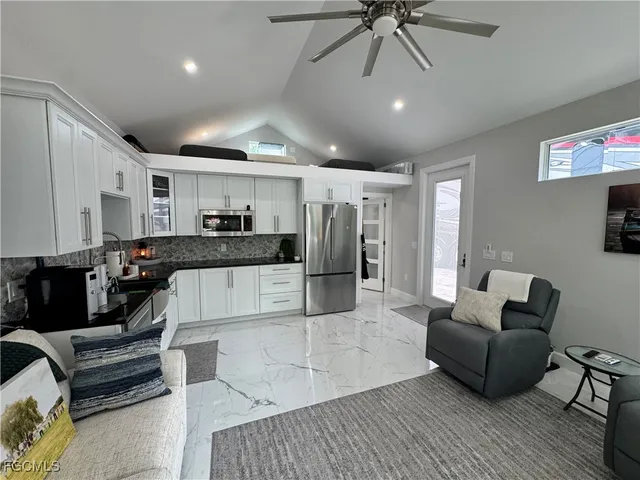 a living room with furniture and kitchen view