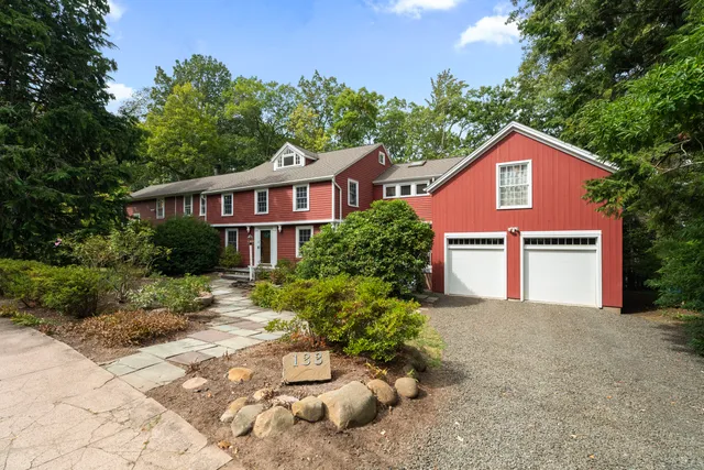 a front view of a house with a yard and trees