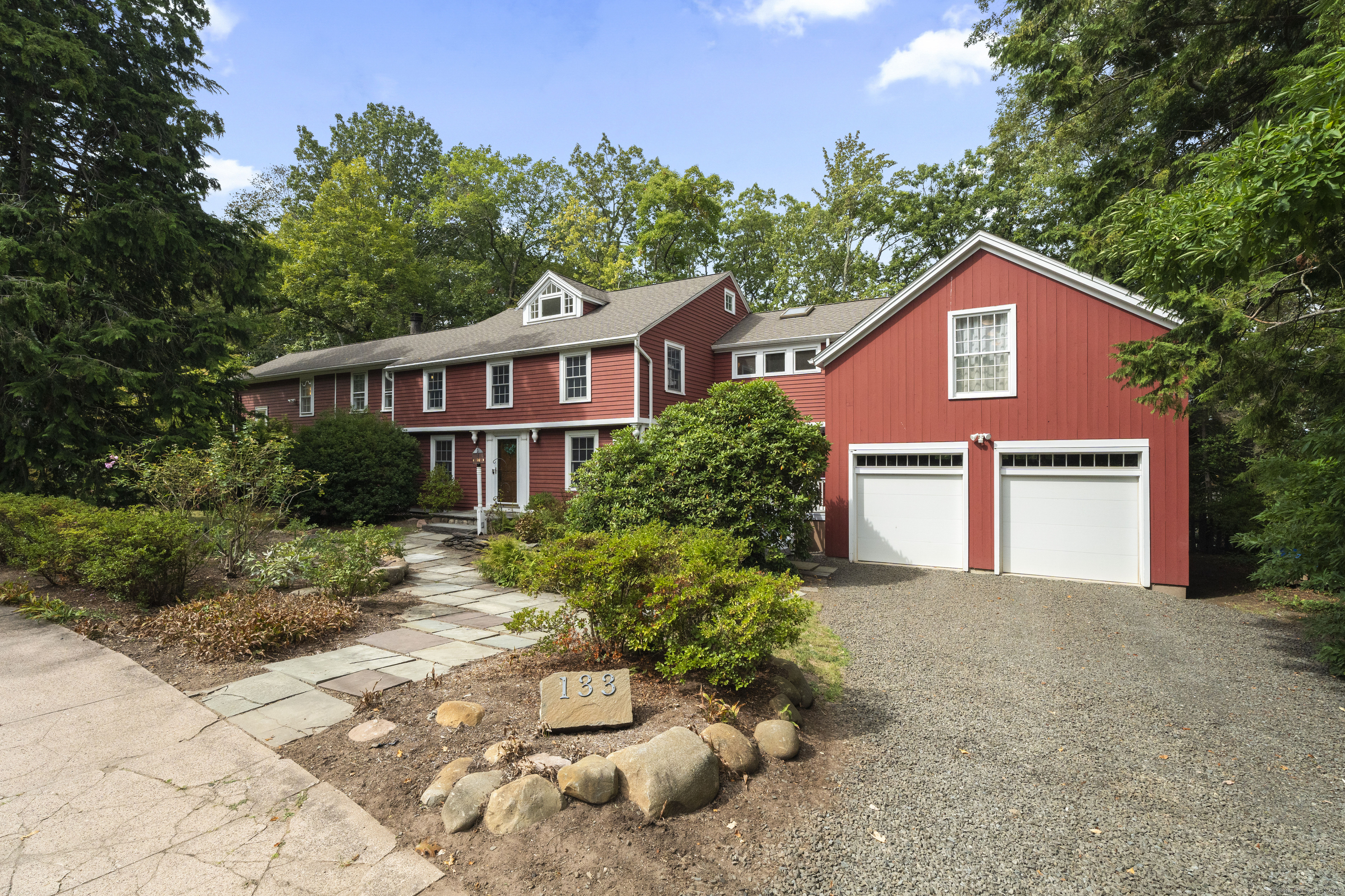 a front view of a house with a yard and trees