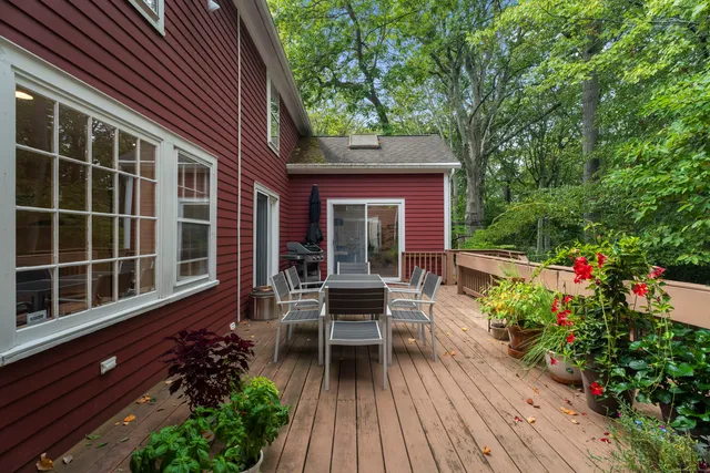 a view of a patio with table and chairs with wooden floor and fence