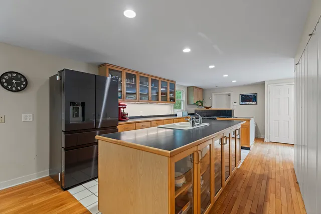 a kitchen with stainless steel appliances granite countertop a refrigerator a stove and a wooden floors