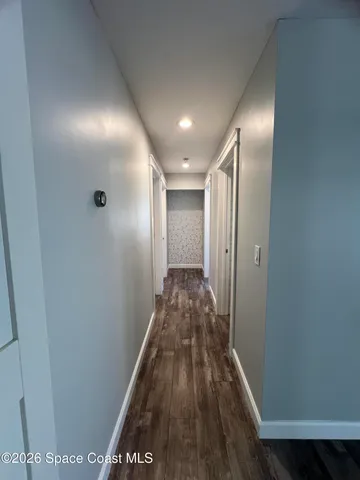a view of hallway with wooden floor