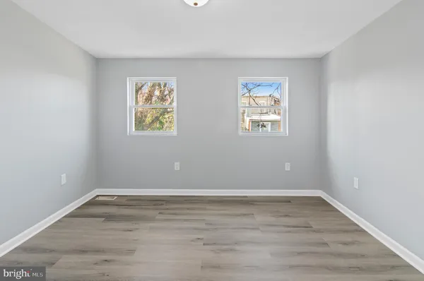 an empty room with wooden floor and window