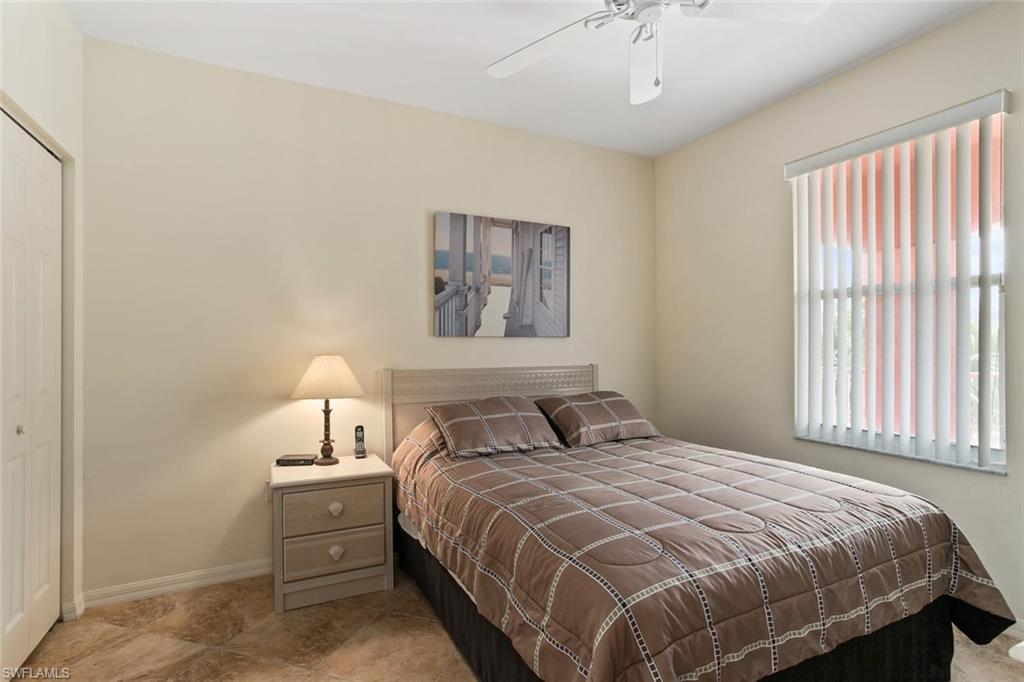 519 Roma Court, Unit 306 Naples, FL 34110 - Photo 11 of 15 a bedroom with a bed and a night stand