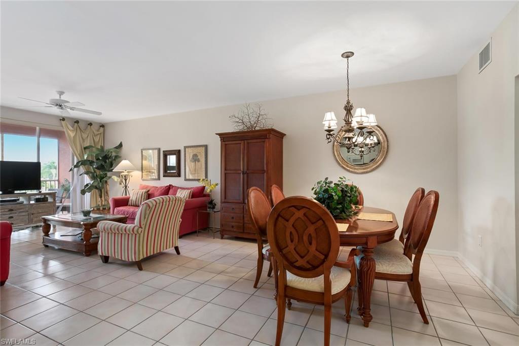 519 Roma Court, Unit 306 Naples, FL 34110 - Photo 4 of 15 a living room with furniture a chandelier and a wooden floor