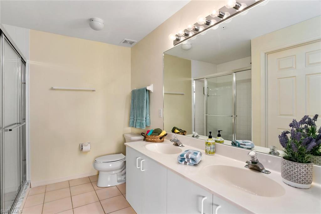519 Roma Court, Unit 306 Naples, FL 34110 - Photo 10 of 15 a bathroom with a double vanity sink mirror and toilet
