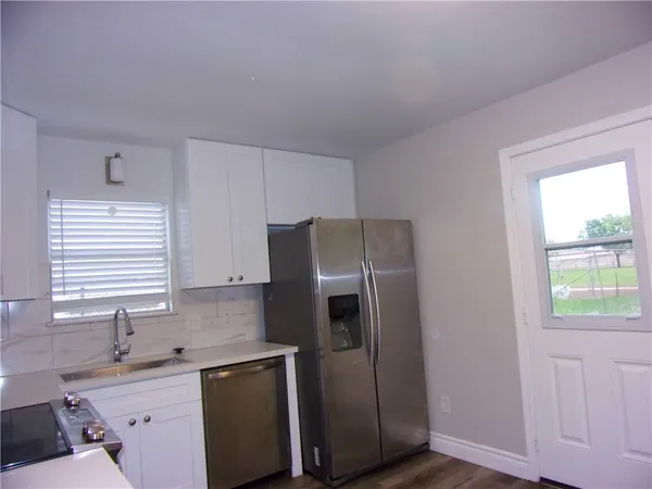 a kitchen with stainless steel appliances granite countertop a refrigerator and a sink