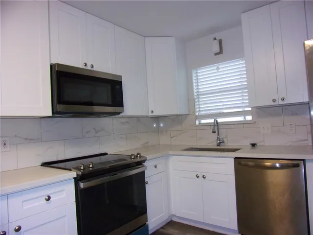 a kitchen with a sink a stove and cabinets