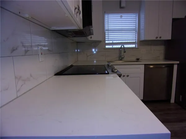 a kitchen with a sink a stove and cabinets