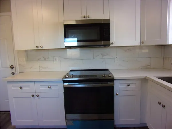 a kitchen with microwave cabinets and stove top oven