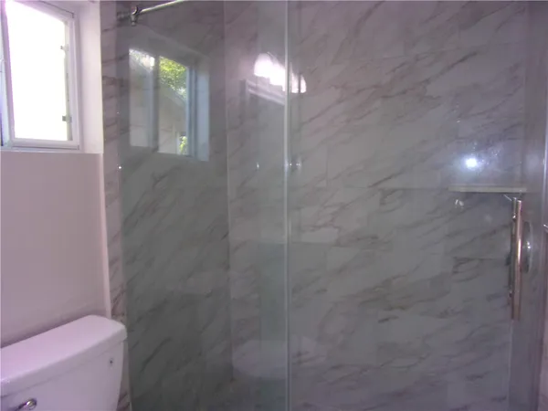 a bathroom with a toilet and a shower