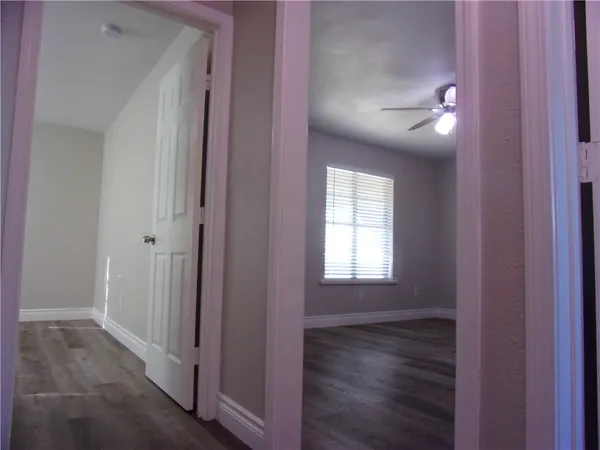 a view of empty room with wooden floor