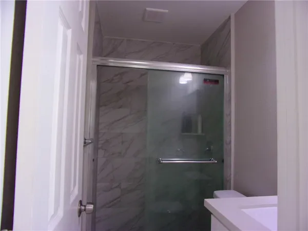 a bathroom with a glass shower door