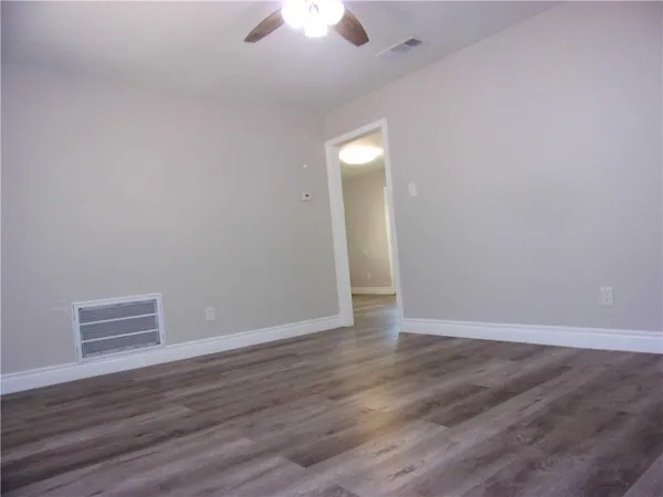 a view of an empty room with wooden floor