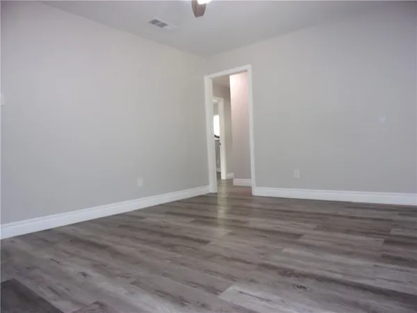 a view of an empty room with wooden floor