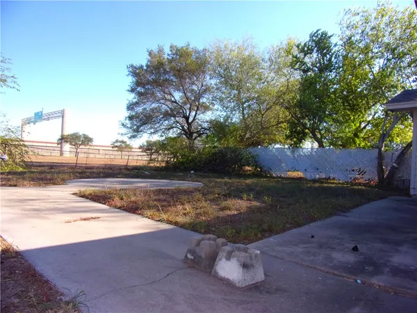 a view of a yard with wooden fence