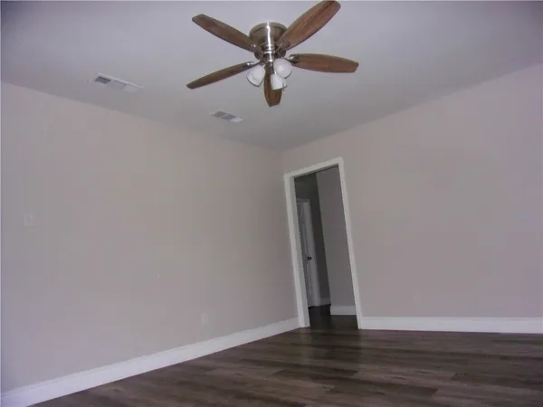 a view of an empty room with wooden floor