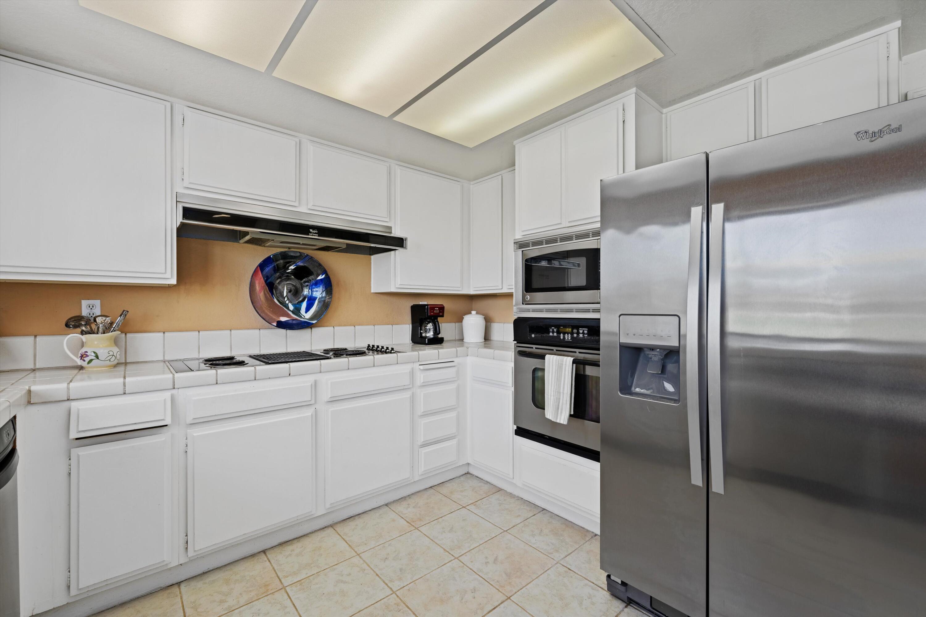56 Maximo Way Palm Desert, CA 92260 - Photo 15 of 29 a kitchen with granite countertop white cabinets and stainless steel appliances