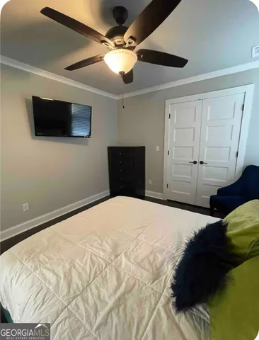 a bedroom with a bed and a ceiling fan