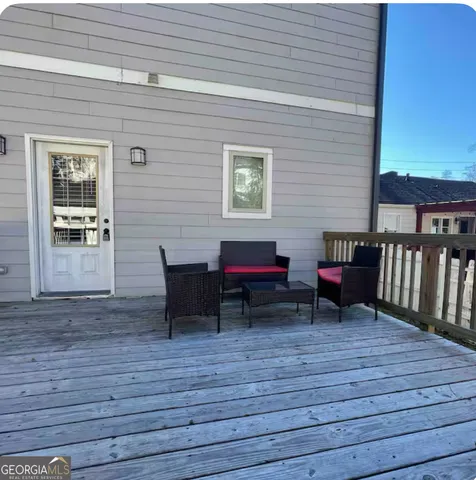 a backyard view of a house with wooden floor and outdoor seating