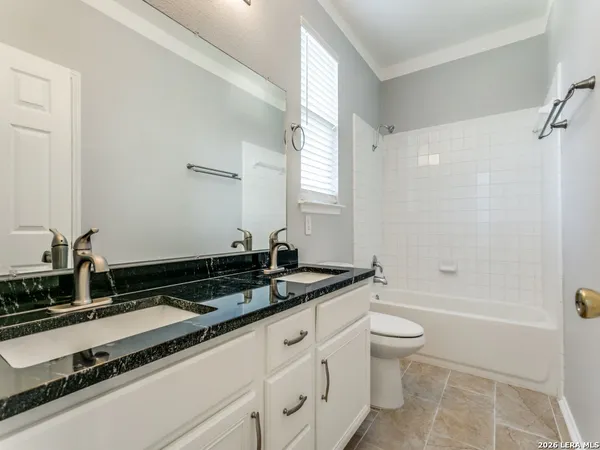 a bathroom with a granite countertop sink a toilet a mirror and bathtub