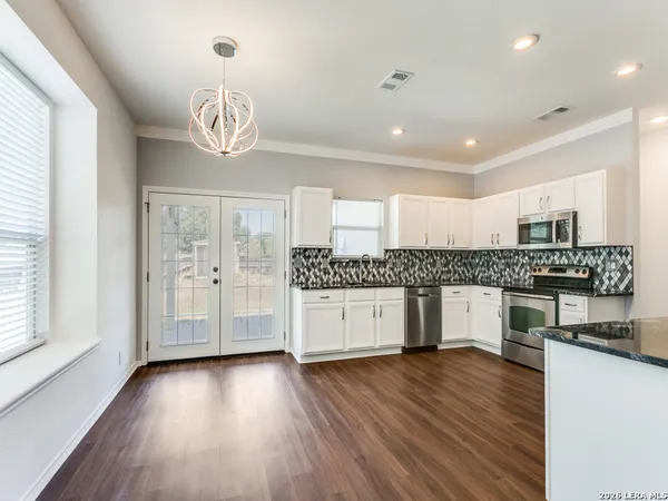 a kitchen with stainless steel appliances granite countertop a stove and wooden floor