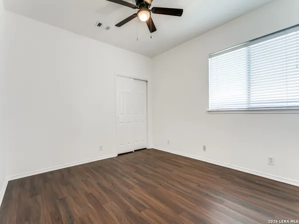 an empty room with wooden floor and windows