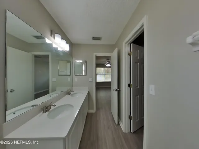 a en suite bathroom with a sink mirror and shower