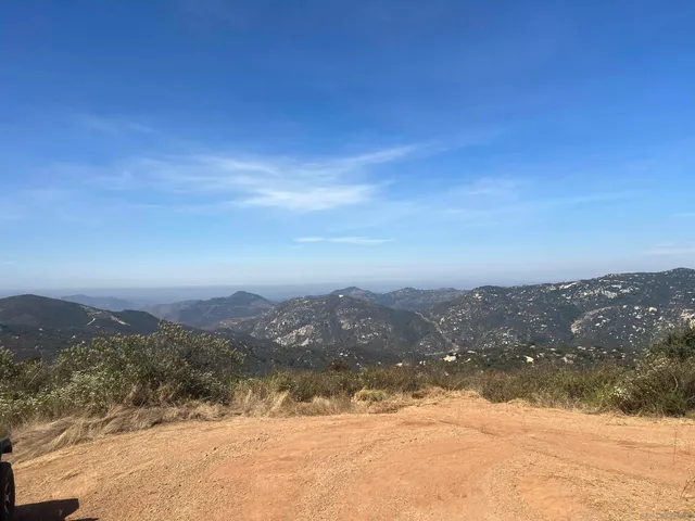 a view of a mountain range with lush green forest