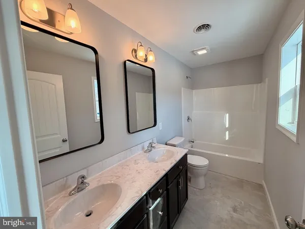 a bathroom with double vanity sinks and a mirror