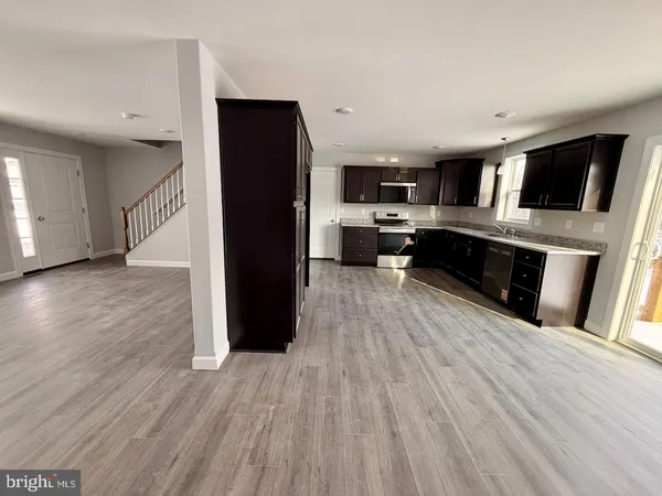 a view of a living room with wooden floor and electronic appliances