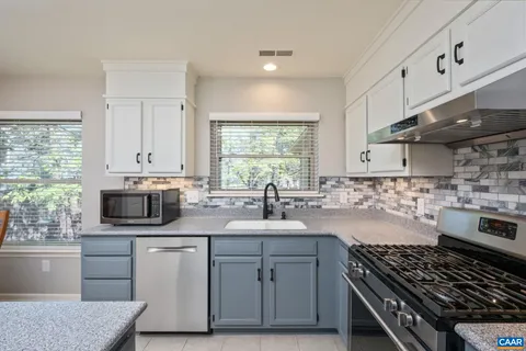 a kitchen with stainless steel appliances a sink stove and cabinets