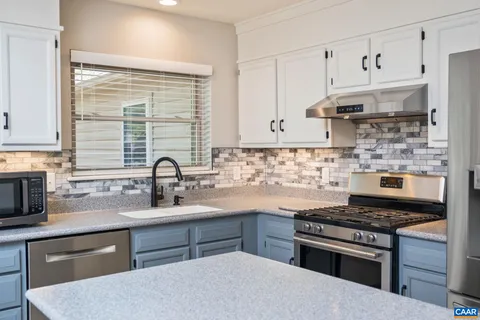 a kitchen with stainless steel appliances a sink stove and cabinets