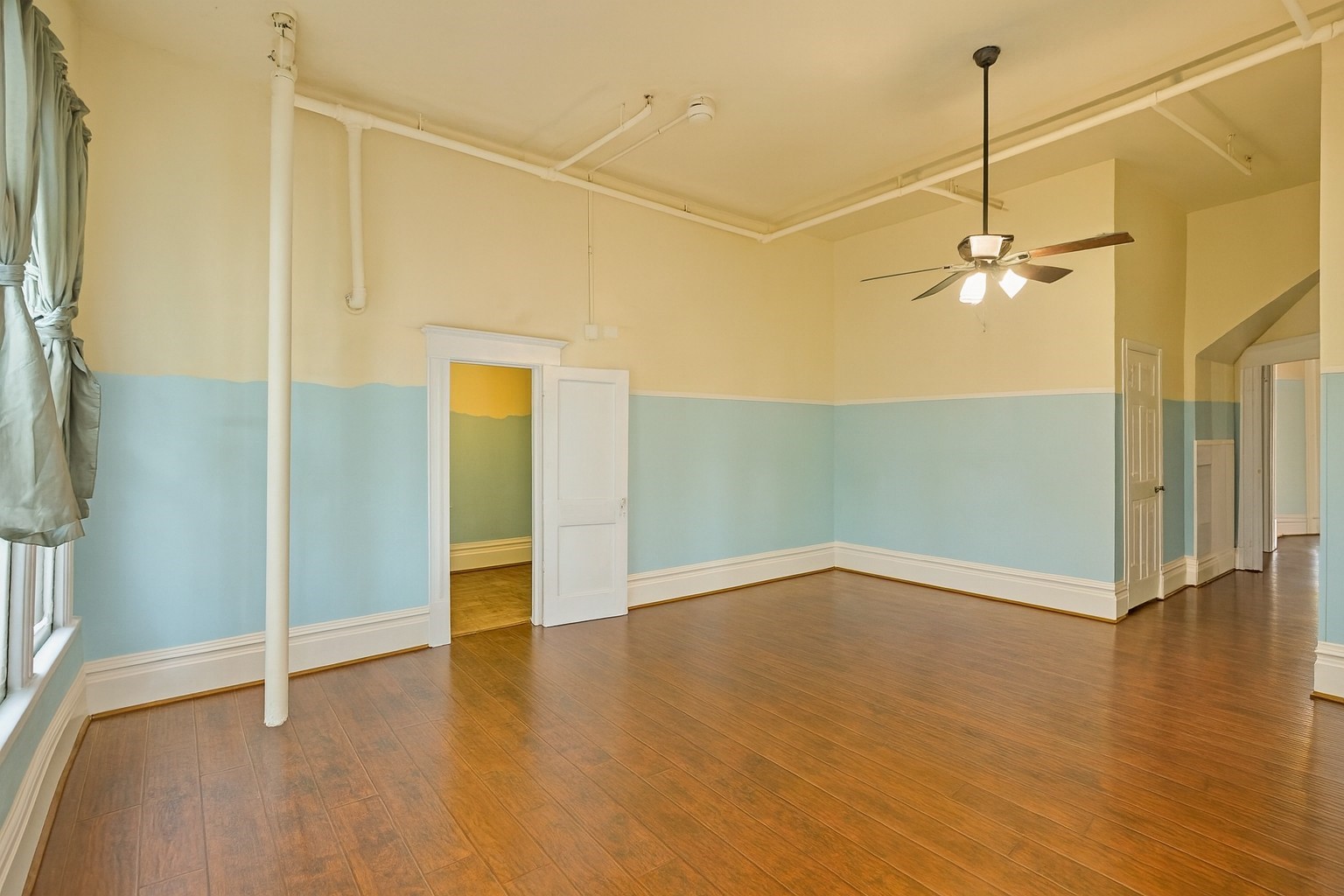 1030 4th Street Rosenberg, TX 77471 - Photo 12 of 39 a view of a room with wooden floor and a ceiling fan