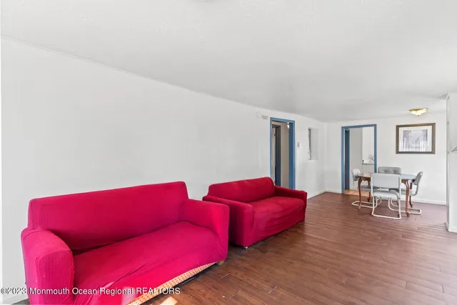 a red couch sitting in a living room with furniture