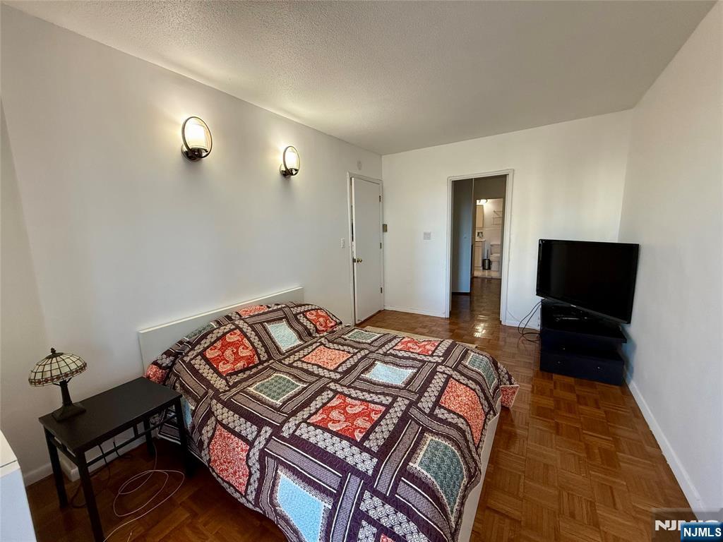 5 Horizon Road, Unit 307 Fort Lee, NJ 07024 - Photo 11 of 31 a bedroom with a bed and a flat screen tv