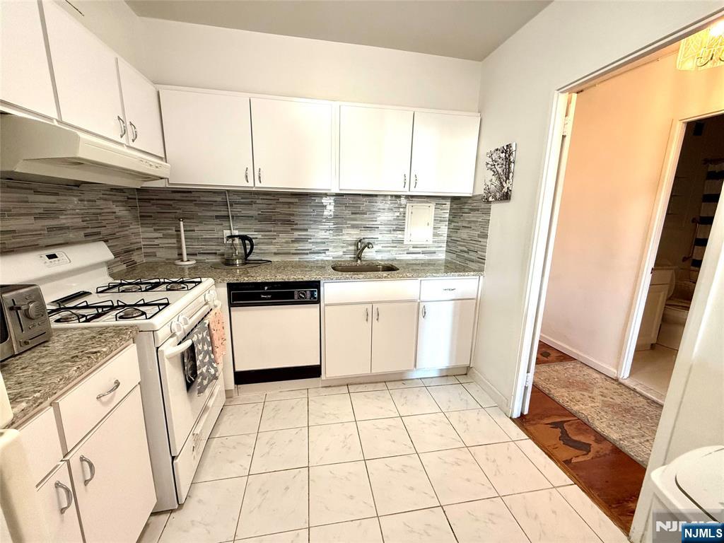 5 Horizon Road, Unit 307 Fort Lee, NJ 07024 - Photo 4 of 31 a kitchen with a stove top oven sink and cabinets