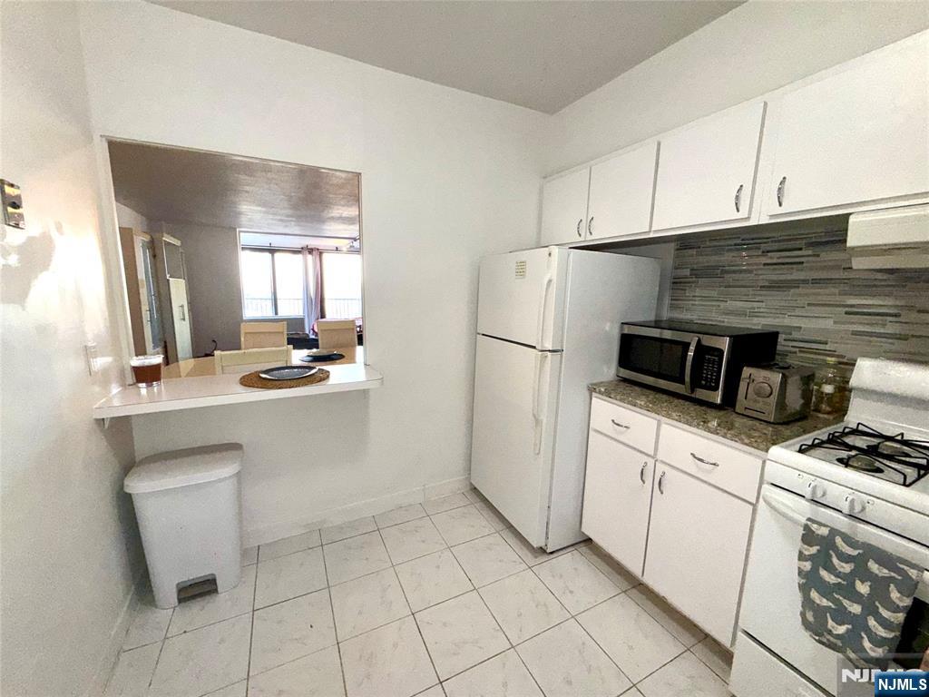 5 Horizon Road, Unit 307 Fort Lee, NJ 07024 - Photo 5 of 31 a kitchen with a stove a sink and a refrigerator