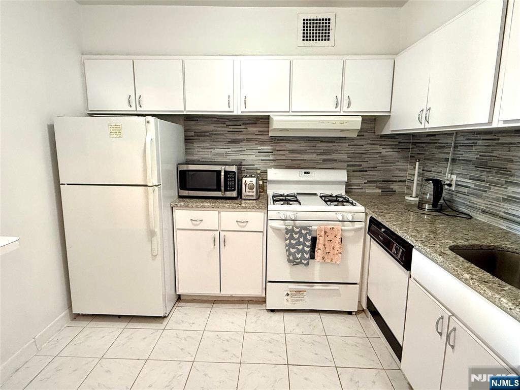 5 Horizon Road, Unit 307 Fort Lee, NJ 07024 - Photo 6 of 31 a kitchen with a stove a refrigerator and a sink