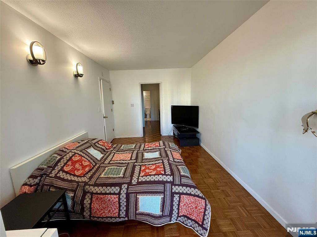 5 Horizon Road, Unit 307 Fort Lee, NJ 07024 - Photo 10 of 31 a bedroom with a bed and a flat screen tv